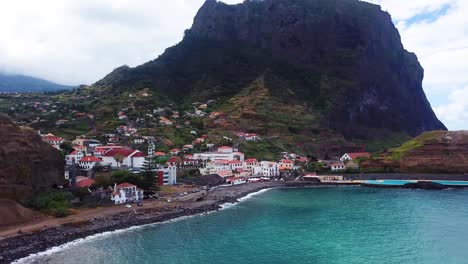 Aerial-orbit-shot-of-Porto-da-Cruz-town-with-Atlantic-ocean-and-pools