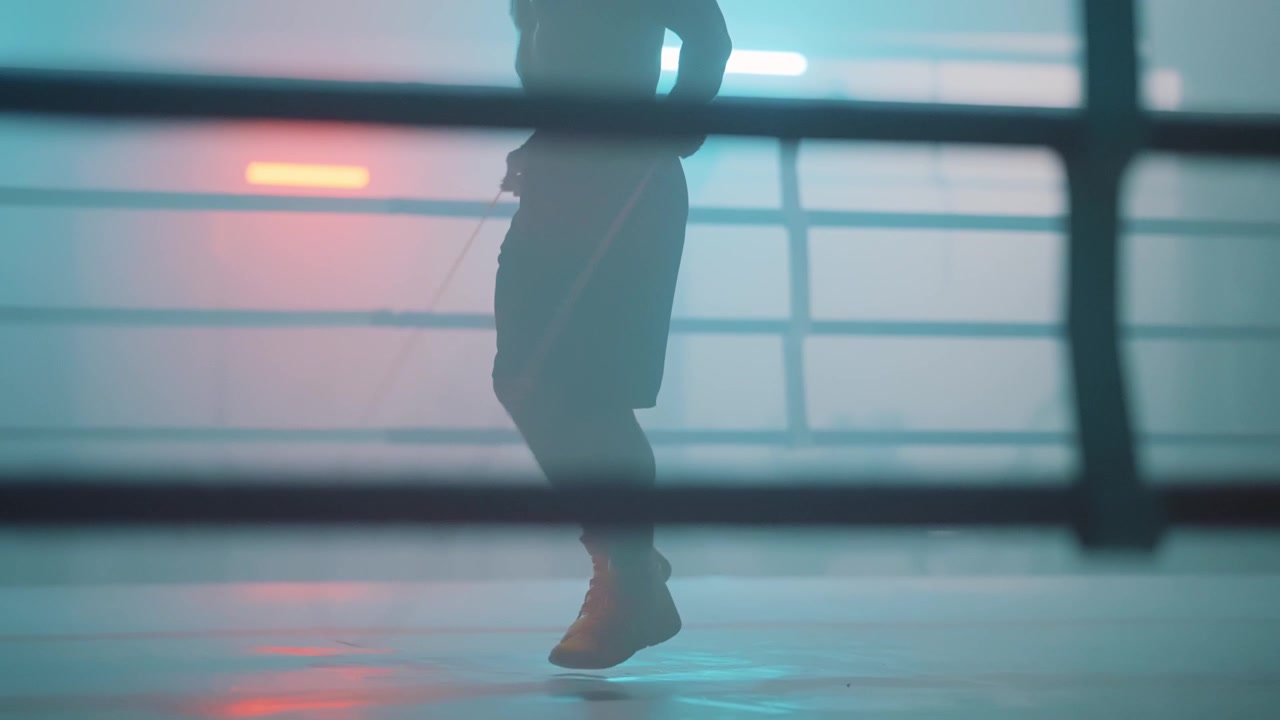 Silhueta de uma Pessoa Pulando Corda em um Ringue de Boxe Iluminado por Neon