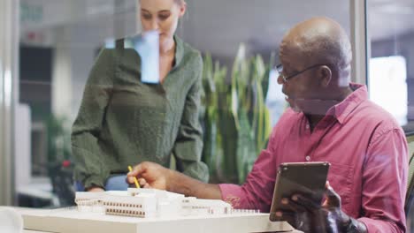 Video-of-diverse-male-and-female-designers-working-with-tablet-and-talking-about-project