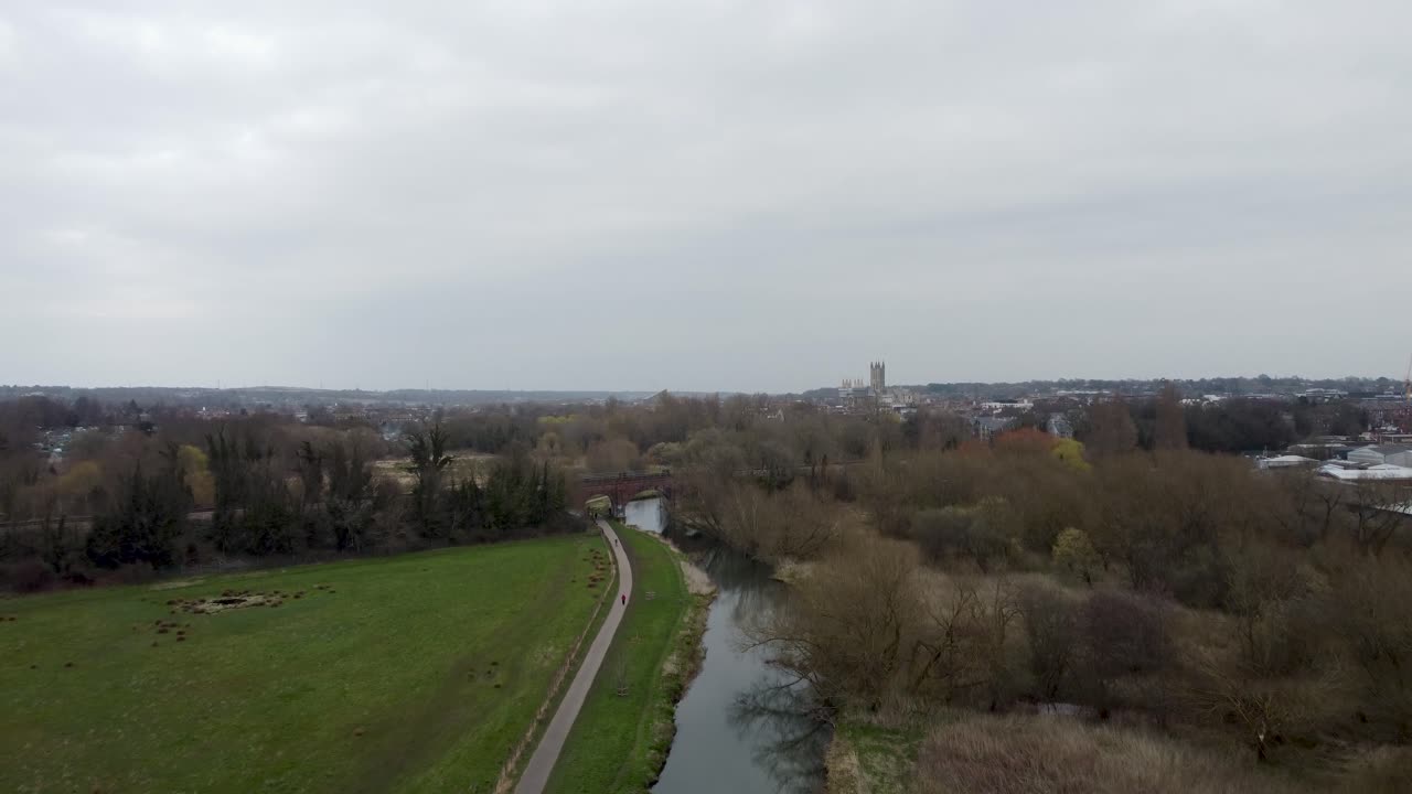 Volo di droni sopra un fiume in un parco che si affaccia sulla città di Canterbury