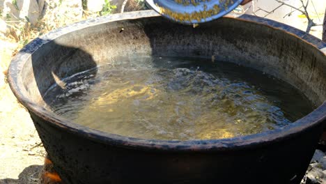 pour wheat into traditional cauldron