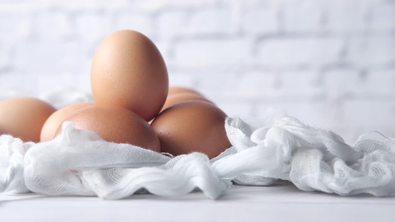 밝은 파란 천에 신선한 갈색 계란