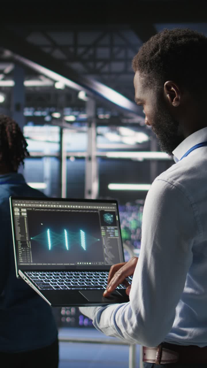 Vertical video Engineers in data center reviewing large language model visualizations on laptop