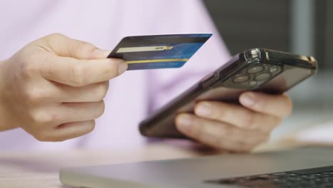 a woman is using credit card to pay for online shopping on an application mobile by smartphone.