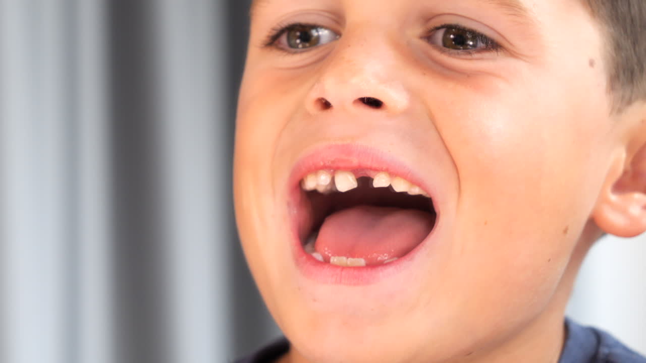 Young Boy Opening Mouth in Mirror Missing a Tooth - Losing Baby Teeth
