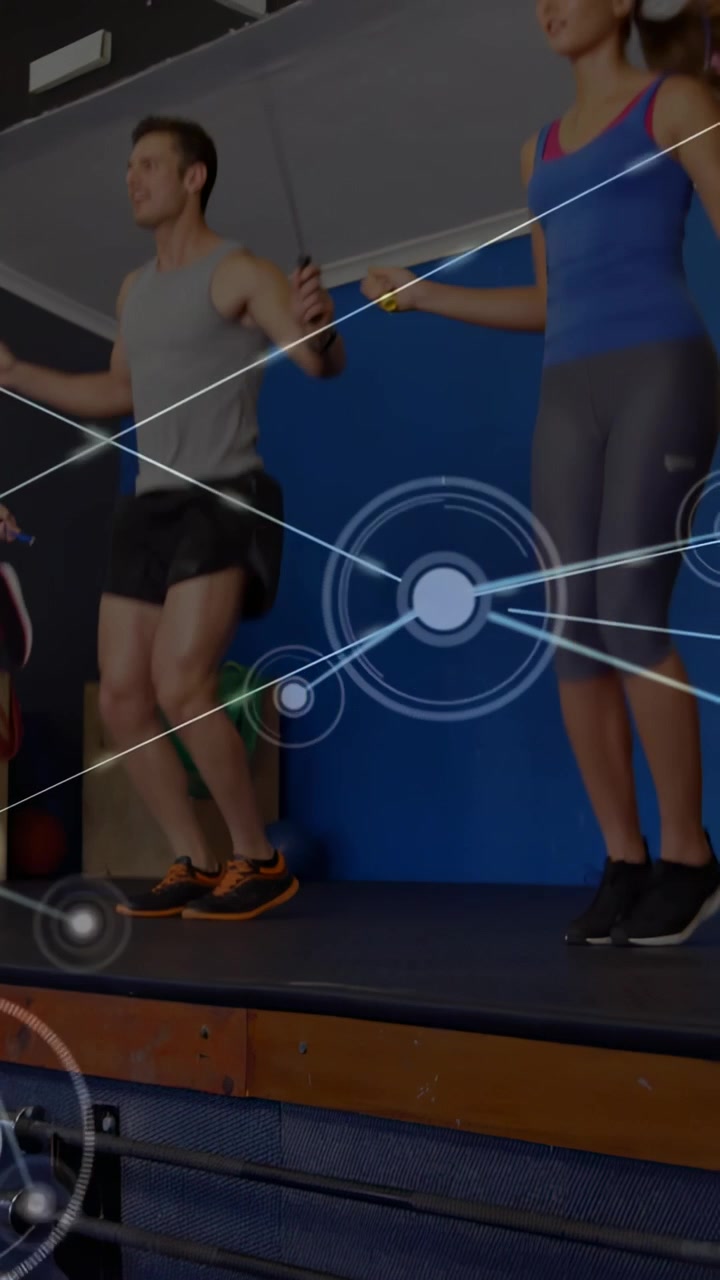 Vertical video: Central pair jumping rope on platform, jumps activating HUD nodes tracking fitness