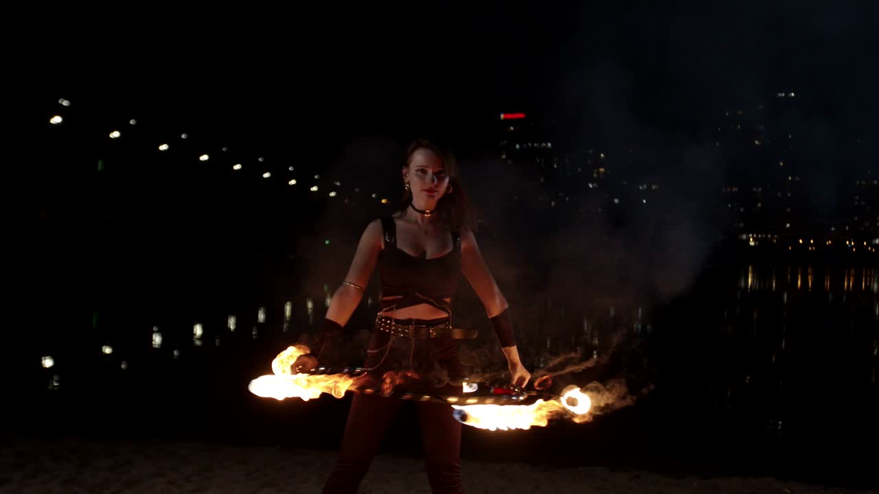 여성 불꽃 쇼 아티스트가 야외에서 불 호프를 회전합니다.