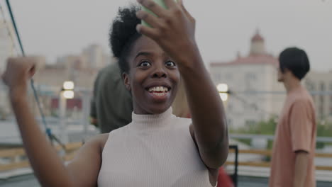woman on a video call with friends at a rooftop party