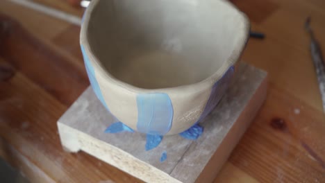 close up of artist painting colorful pottery