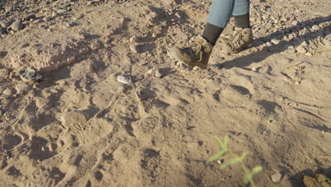 Mujer-Excursionista-Deja-Caer-Un-Saco-De-Dormir-En-La-Tierra-Y-La-Arena-En-Una-Caminata-Por-El-Desierto