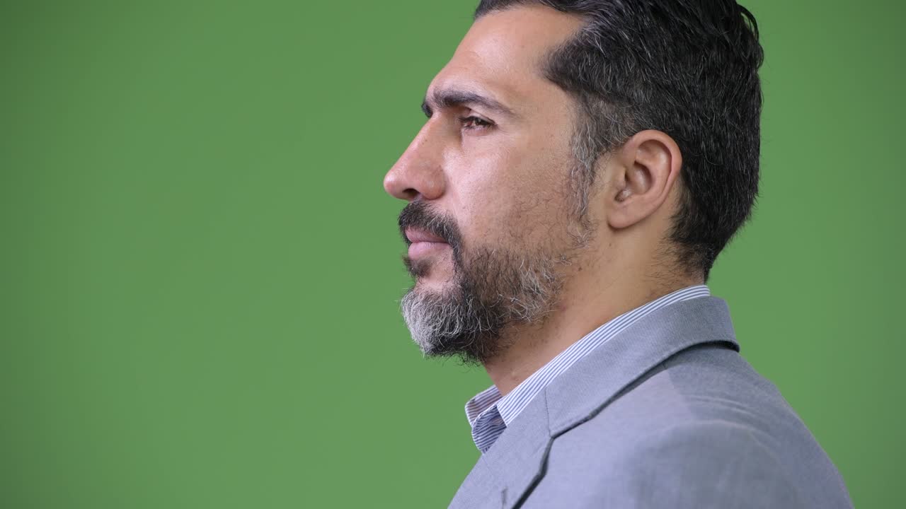 Profile view of handsome Persian bearded businessman smiling