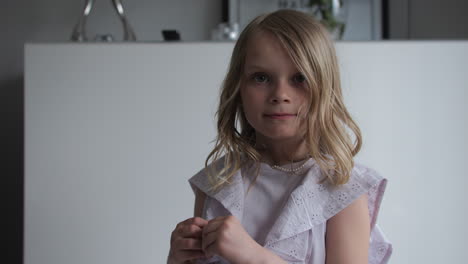 Little-blonde-girl-posing-and-looking-at-camera,-Home-interior-Portrait-photoshoot