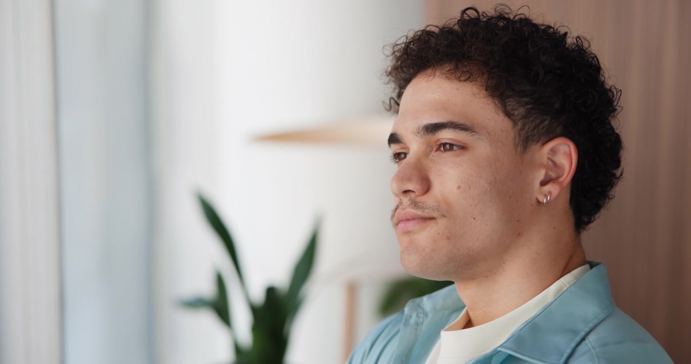 Joven mirando pensativamente por una ventana