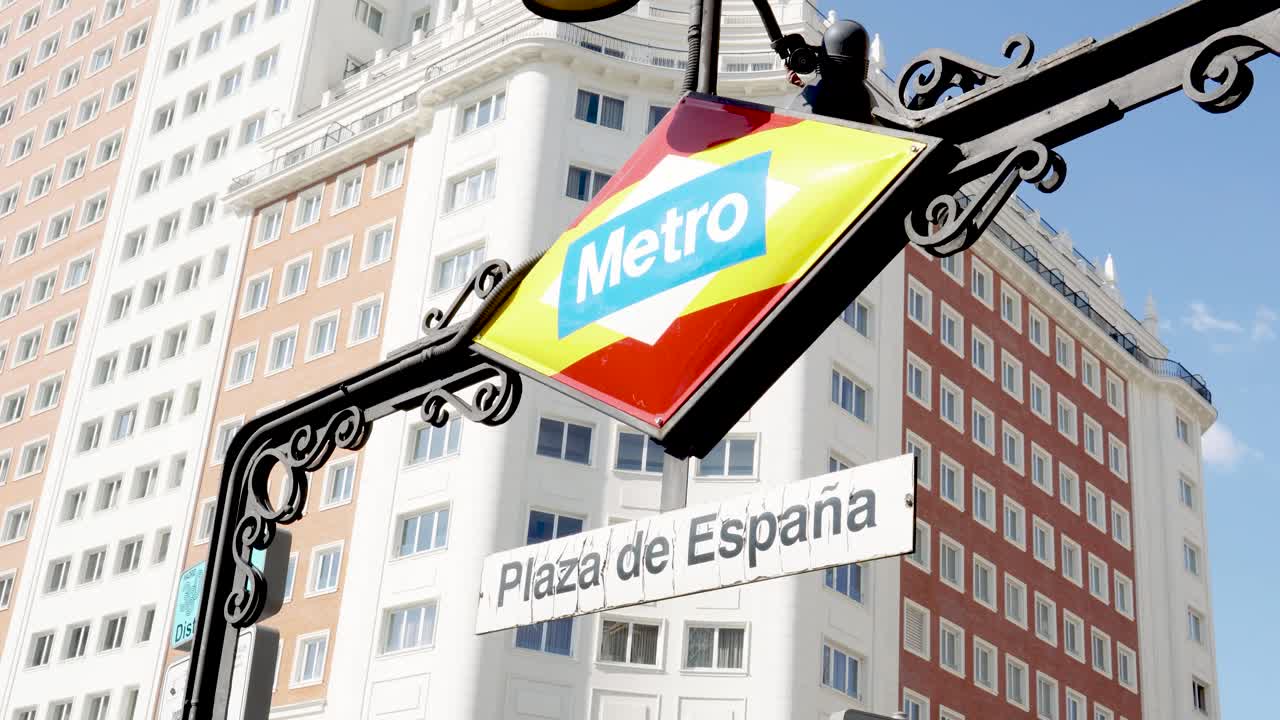 Plaza de España metro station sign with Riu building in background in Madrid, Spain