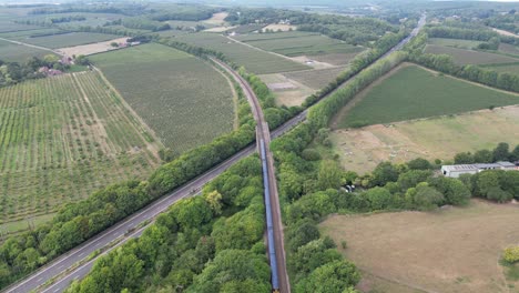 toma aérea siguiendo un tren que sale de canterbury y va por la vía de doble calzada a2