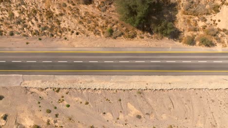 coche zoomando hacia el norte en una carretera del desierto con cielo azul nublado