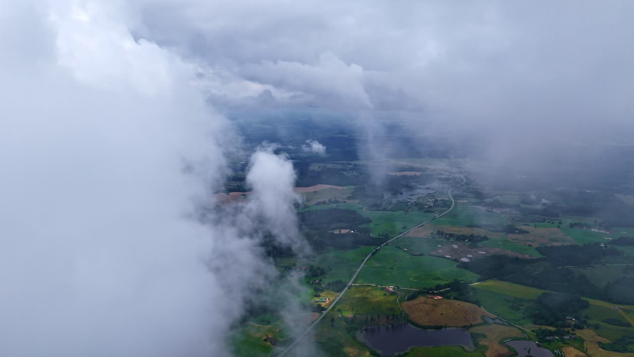 Aerial shot of dense clouds over a dense forest during dawn
