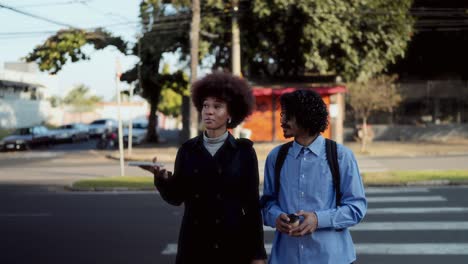 two people walking and talking on a city street