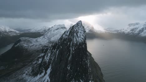 Sunrays-piercing-clouds-over-Segla-mountain,-Senja-Island,-Norway,-aerial-view