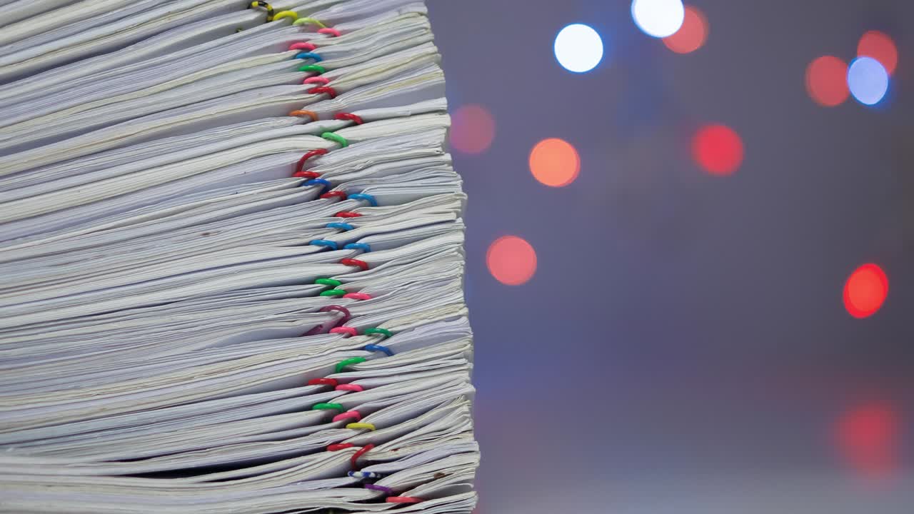 una pila de papeles tiene un bokeh colorido como fondo de lapso de tiempo