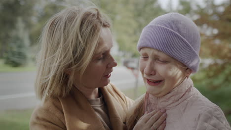 a ten-year-old girl cries, her mother calms her down