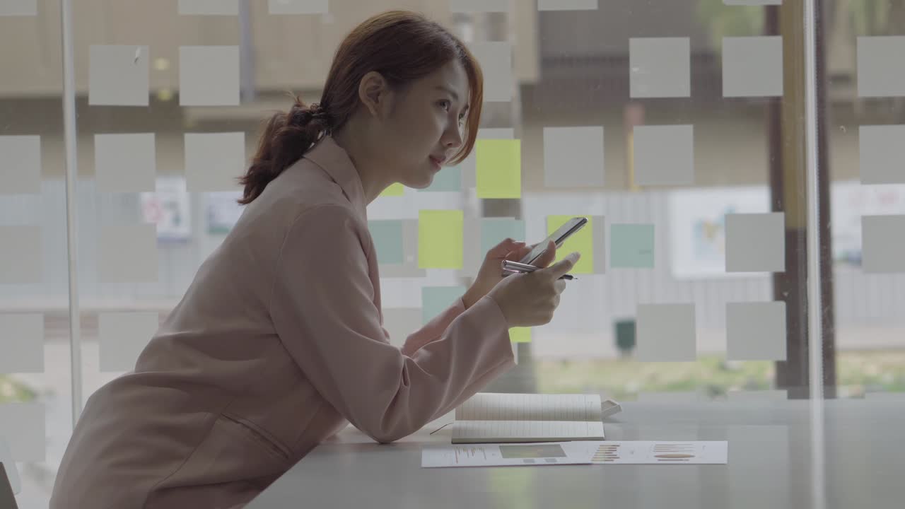 Asian women shop online, enter the PIN numbers on mobile and hold a credit card. Video recording of Asian teens using credit cards to shop online on their mobile phones.