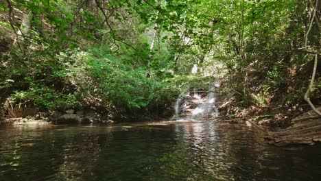 Waterfall-along-the-Riells-River-flows-into-a-crystal-clear-pool,-Catlonia-Spain