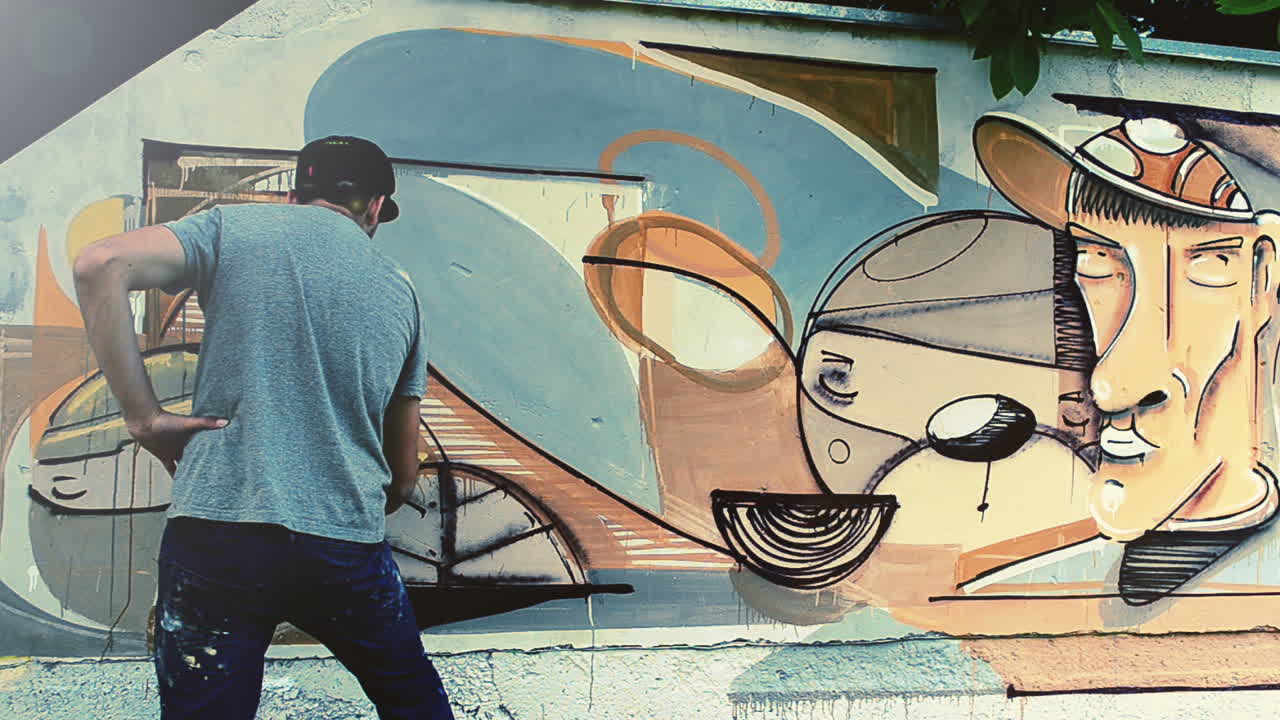 El artista dibuja grafitis en una valla. Grafiti en una valla.