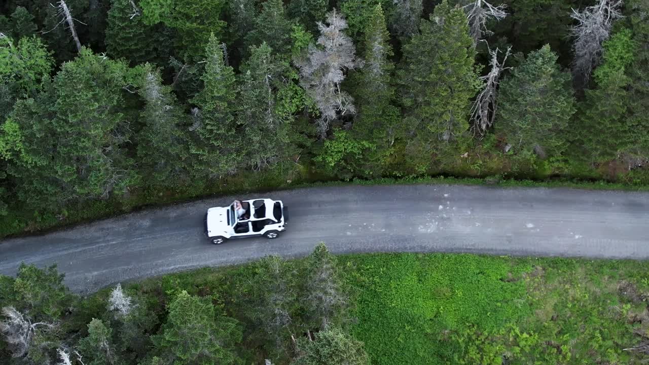 Ripresa aerea ravvicinata tramite drone di una jeep sulla strada forestale di Stowe, Vermont