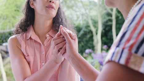 Mother-and-daughter-holding-hands-while-talking-in-the-garden-4K-4k