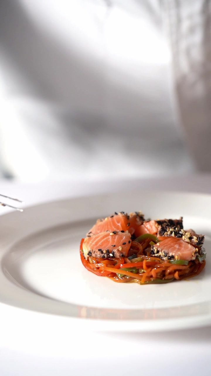 Chief plating a gourmet dish with vegetables and meat in a minimalist style, close up shot, insert shot