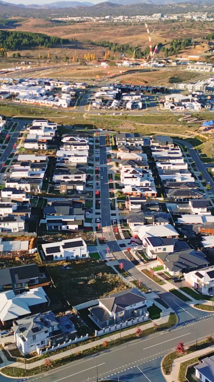 Vertical drone flying backwards revealing all new houses and suburb in Whitlam, Canberra.Expansive housing development reveal addressing Australia's housing crisis with modern residential construction