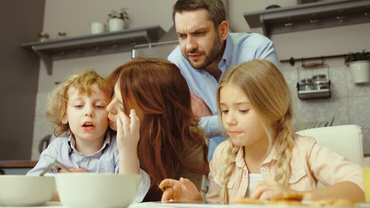 famiglia che fa colazione e utilizza un tablet in cucina