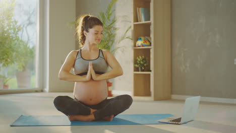 mujer embarazada haciendo yoga en casa