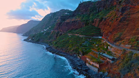 amazing high mountains with gardens on the slopes. the atlantic ocean hits the rocks at the coast of the madeira islands, portugal. drone footage.