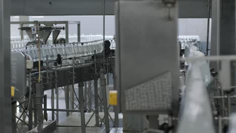cinta transportadora con botellas de agua potable en una planta de bebidas moderna