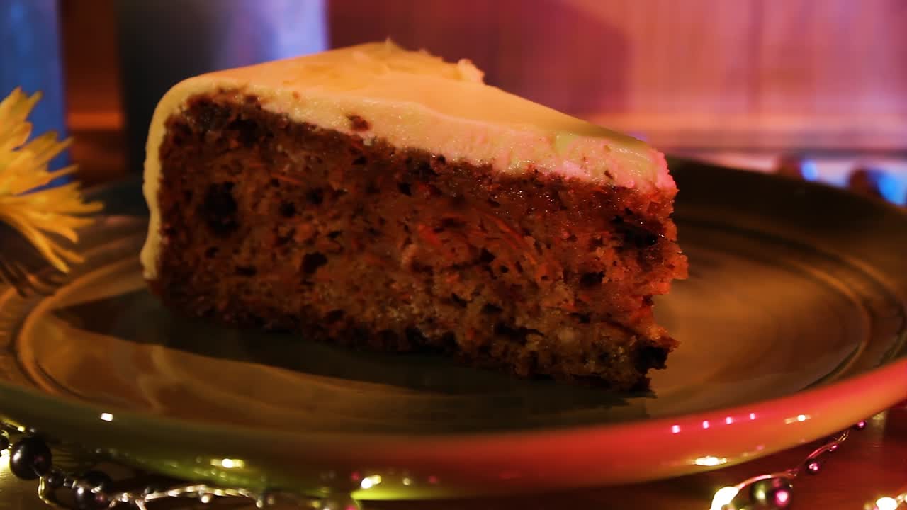rebanada de delicioso pastel de zanahoria vegano en un plato con decoraciones ligeras en la mesa