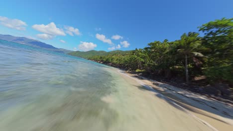 drone flying at low altitude over playa ermitano beach, samana in dominican republic