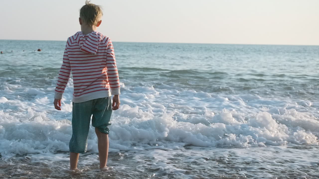 niño jugando en las olas del océano