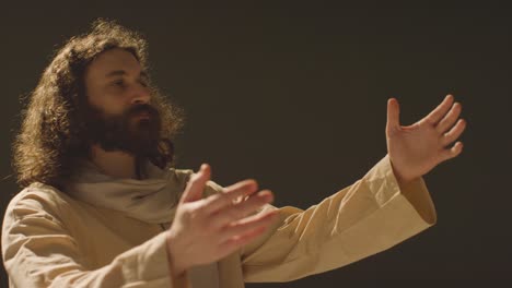 retrato de un hombre vestido con túnicas con cabello largo y barba que representa la figura de jesucristo levantando las manos en oración 2