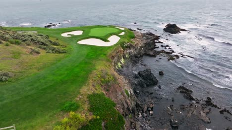 wide orbiting drone shot of the iconic 7th hole at pebble beach golf links in california