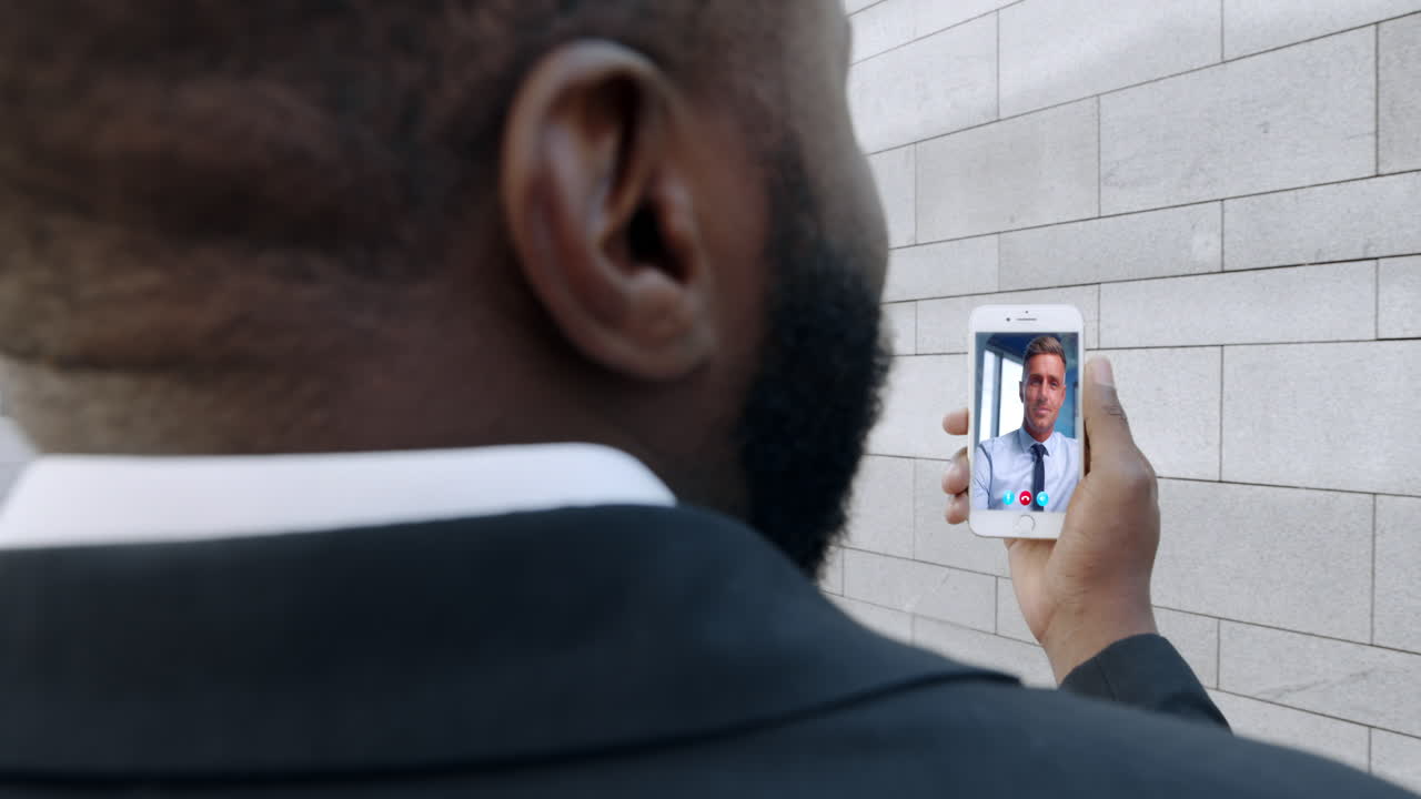Primo piano di un uomo d'affari impegnato in una videoconferenza tramite cellulare con un partner aziendale