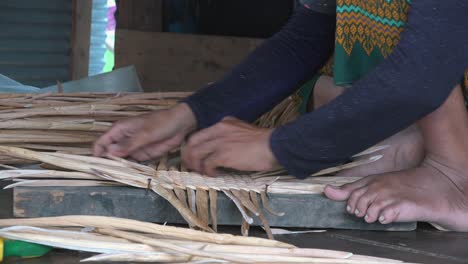 khmer woman using scissors for weaving palm tree leaf