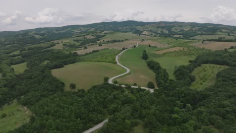 Road-snakes-up-lush-mountainside-of-remote-countryside,-Thessaly,-Greece