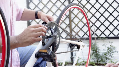 repairing bicycle outdoors, person adjusting chain and pedal mechanism