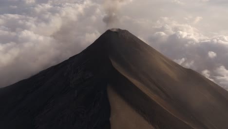 Drone-tilting-toward-an-active-Volcano,-smoking-in-high-elevations-of-Guatemala