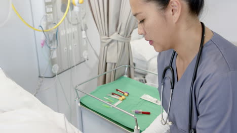 diverse female doctor giving injection to senior female patient in hospital room, slow motion