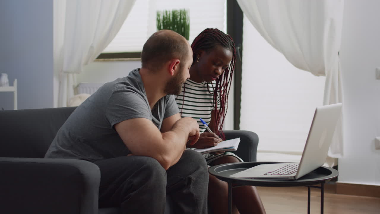 Young interracial couple planning budget for tax payment