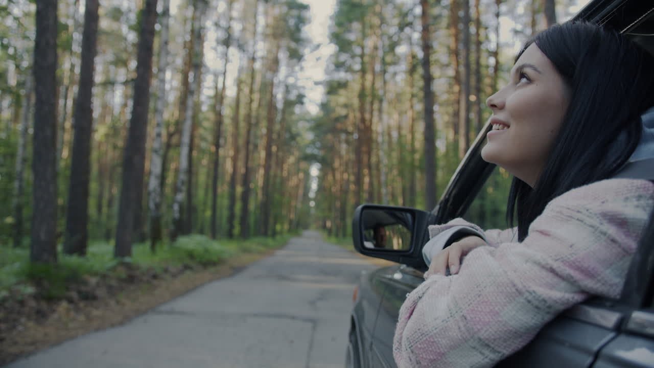 Woman Driving Through a Forest