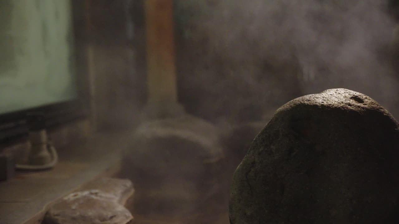 ryokan inn의 일본 온천에서 증기가 아오르고 있습니다.